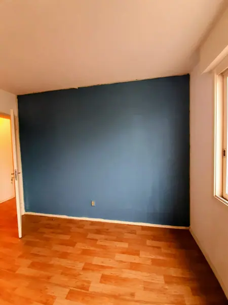 Ambiente com parede azul e piso de madeira